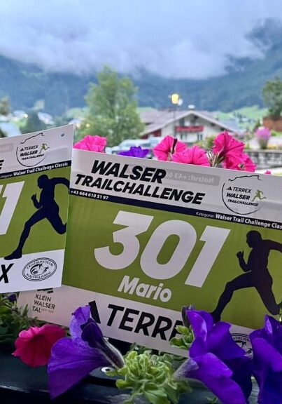 Walser Trail Challenge: Startnummern 331 (Ines) und 301 (Mario) vor Alpenkulisse - We Run 4 Fun!